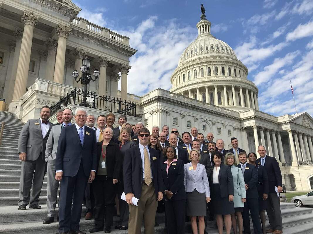 janice allen jackson and other political figues standing infront of the capital building