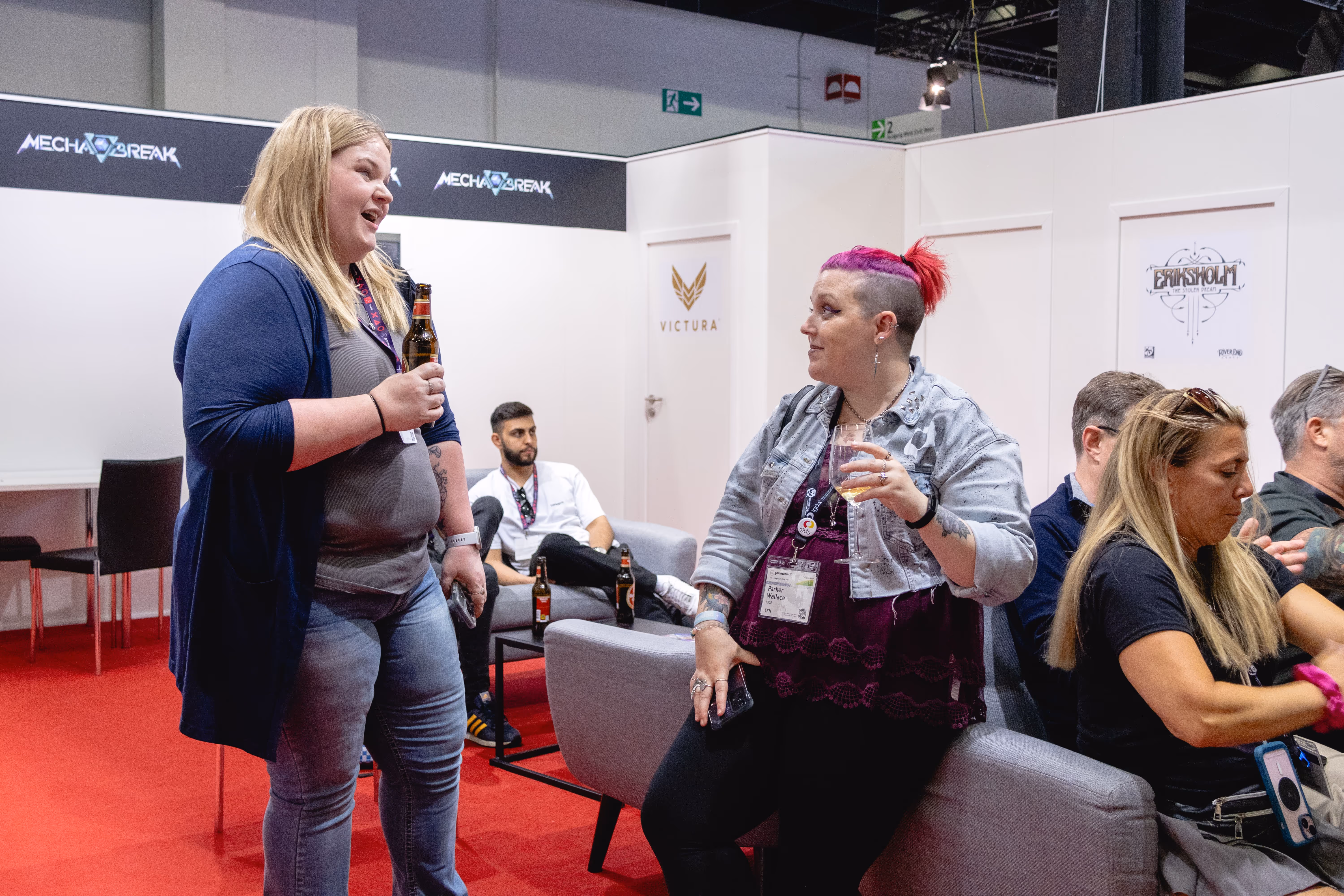 Two women talking in a room with a red carpet. -  ÜberStrategist Images