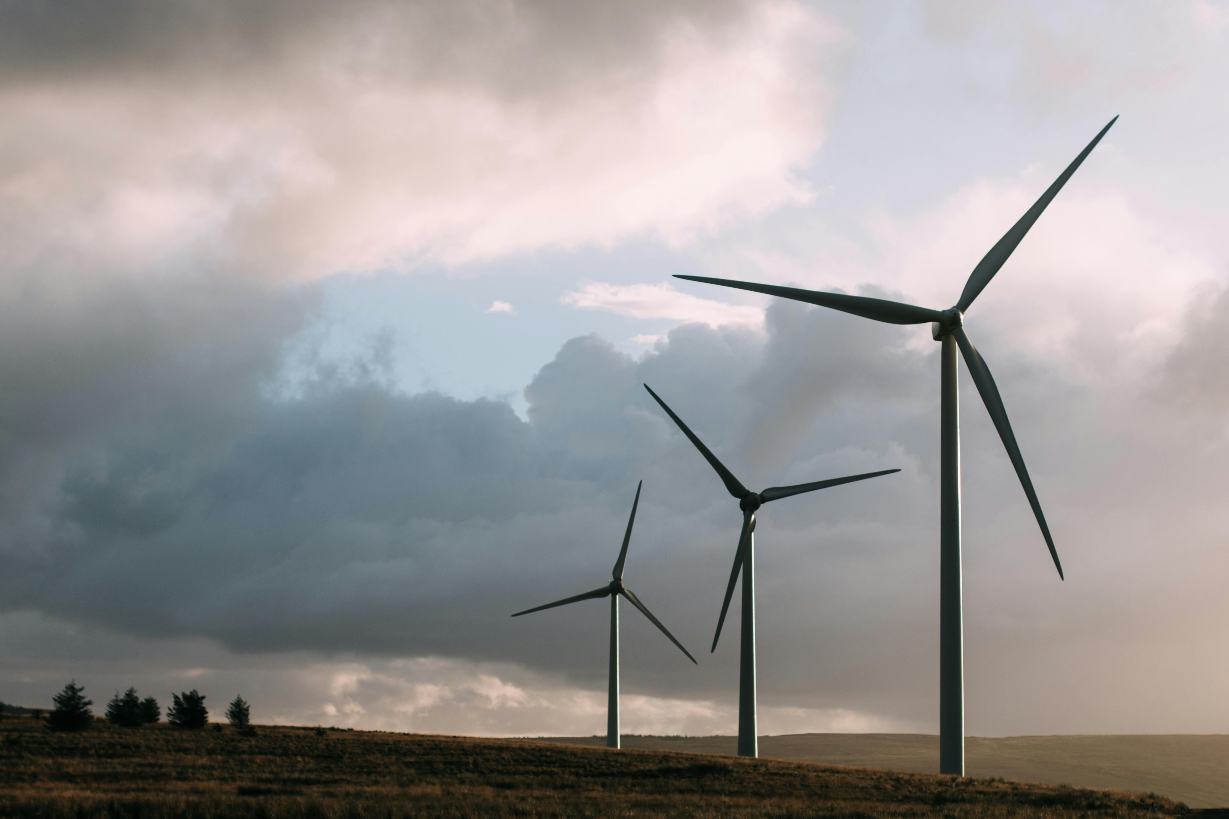 Wind turbines generating renewable energy under a dramatic cloudy sky.