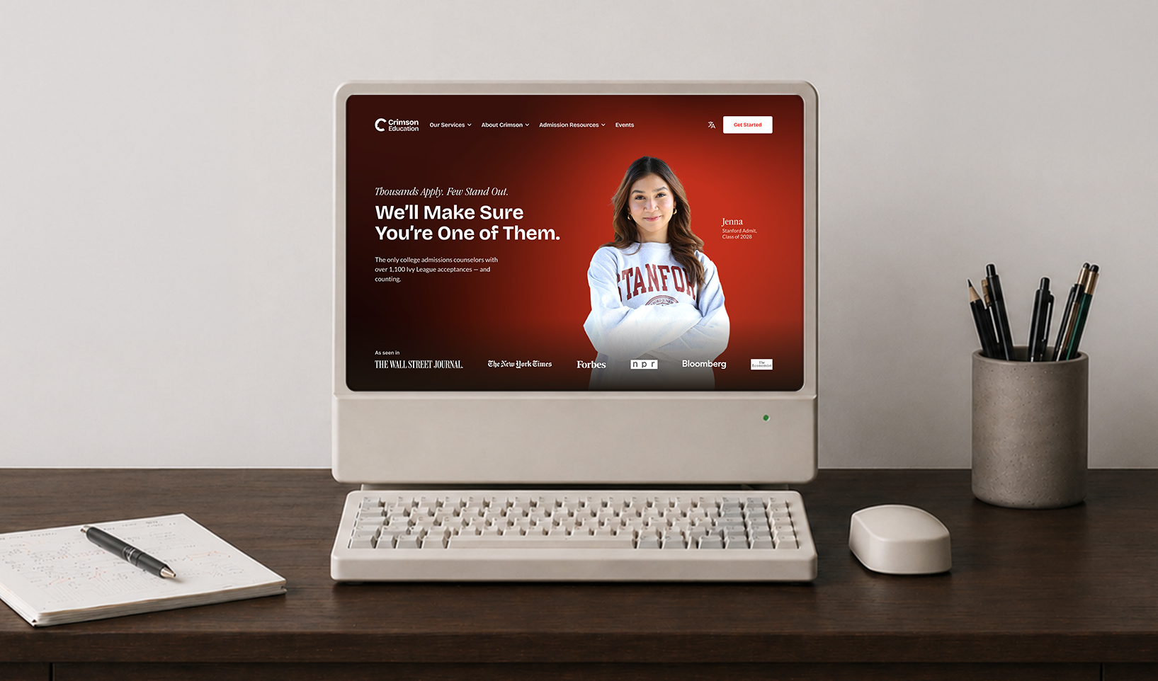 Vintage computer on desk showing Crimson Education website with student wearing Stanford sweatshirt.