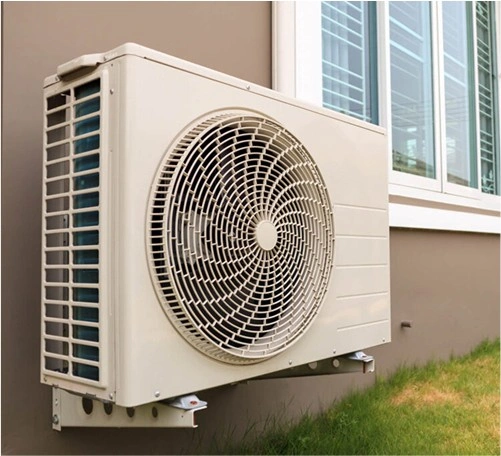 White air conditioning unit mounted on exterior wall near window