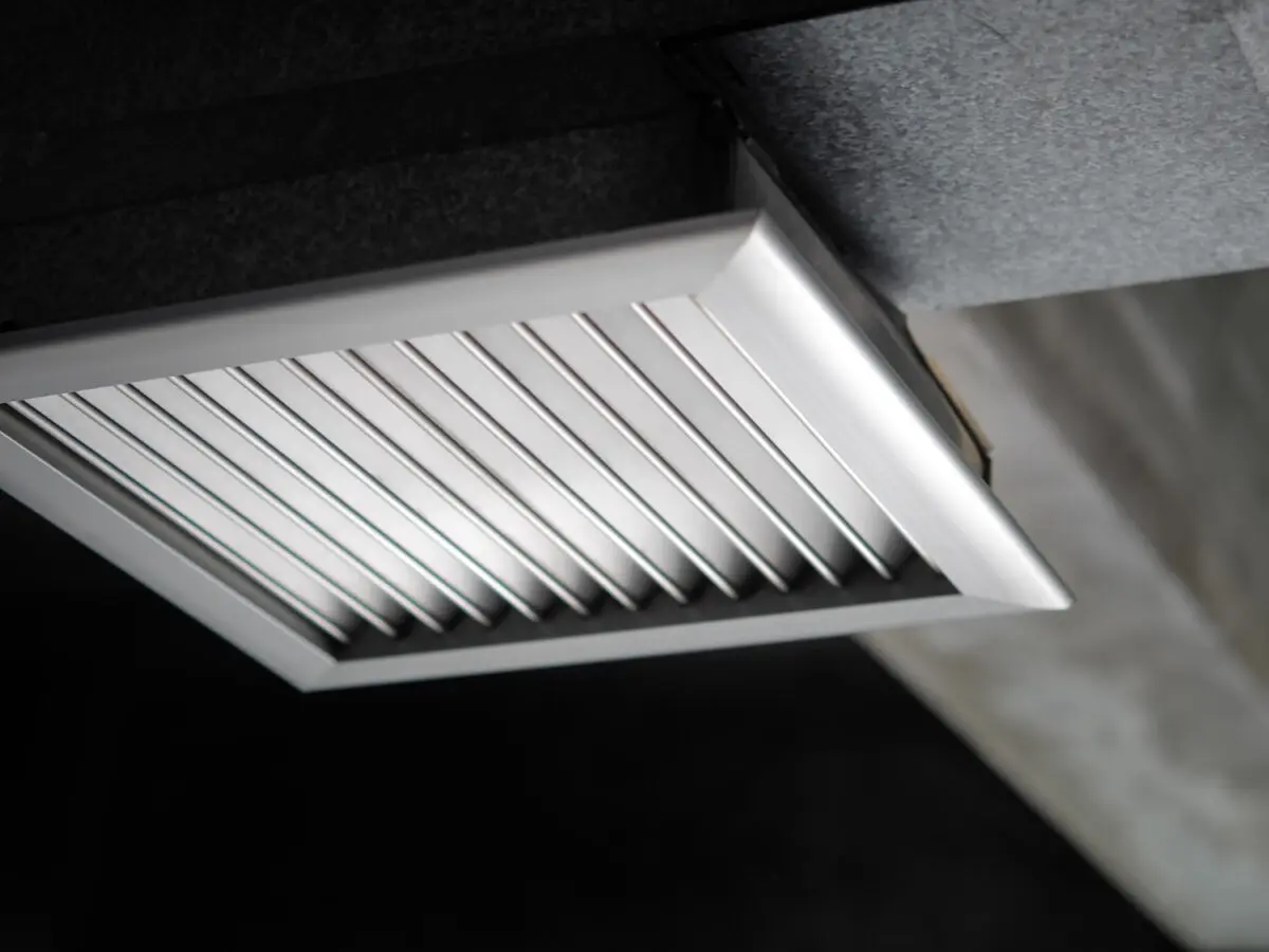 Close-up of a white rectangular air vent with angled slats