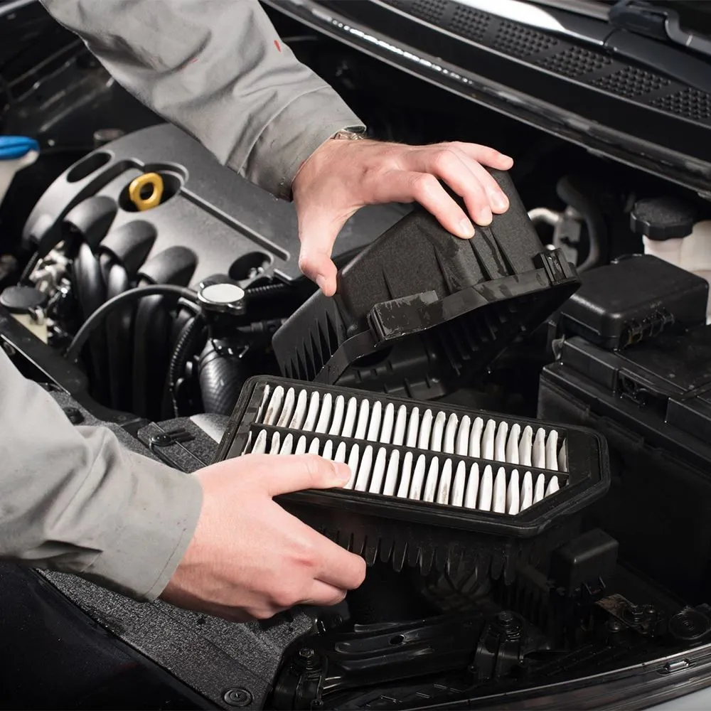 Mechanic removing and replacing car engine air filter