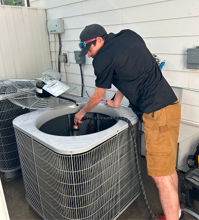 HVAC technician checking and maintaining an outdoor air conditioning unit