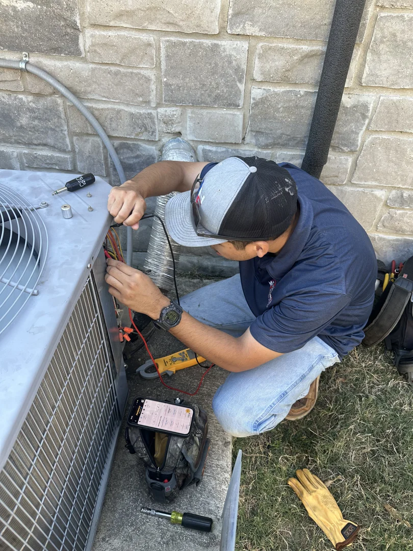 HVAC technician inspecting a residential heating and cooling system in Texas HVAC technician inspecting a residential heating and cooling system in Texas
