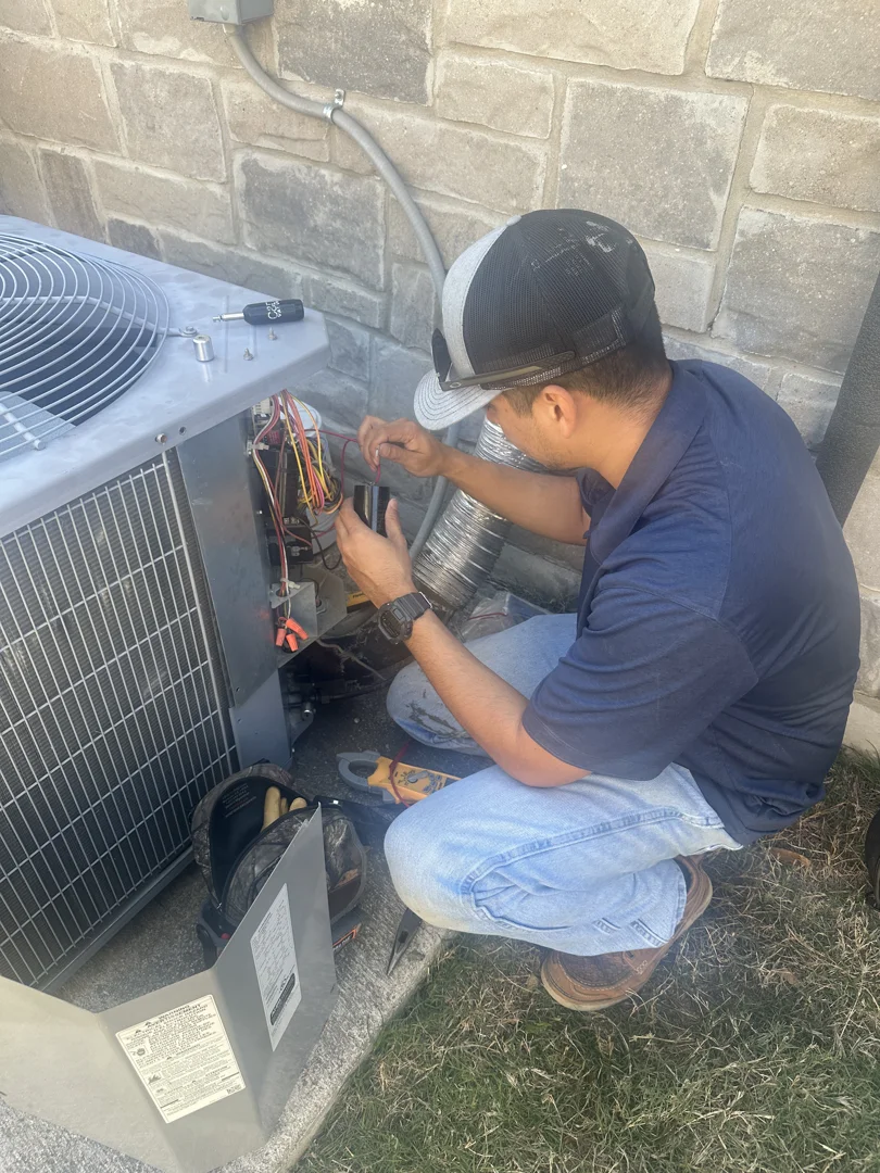 HVAC technician servicing a clean outdoor AC unit in Texas