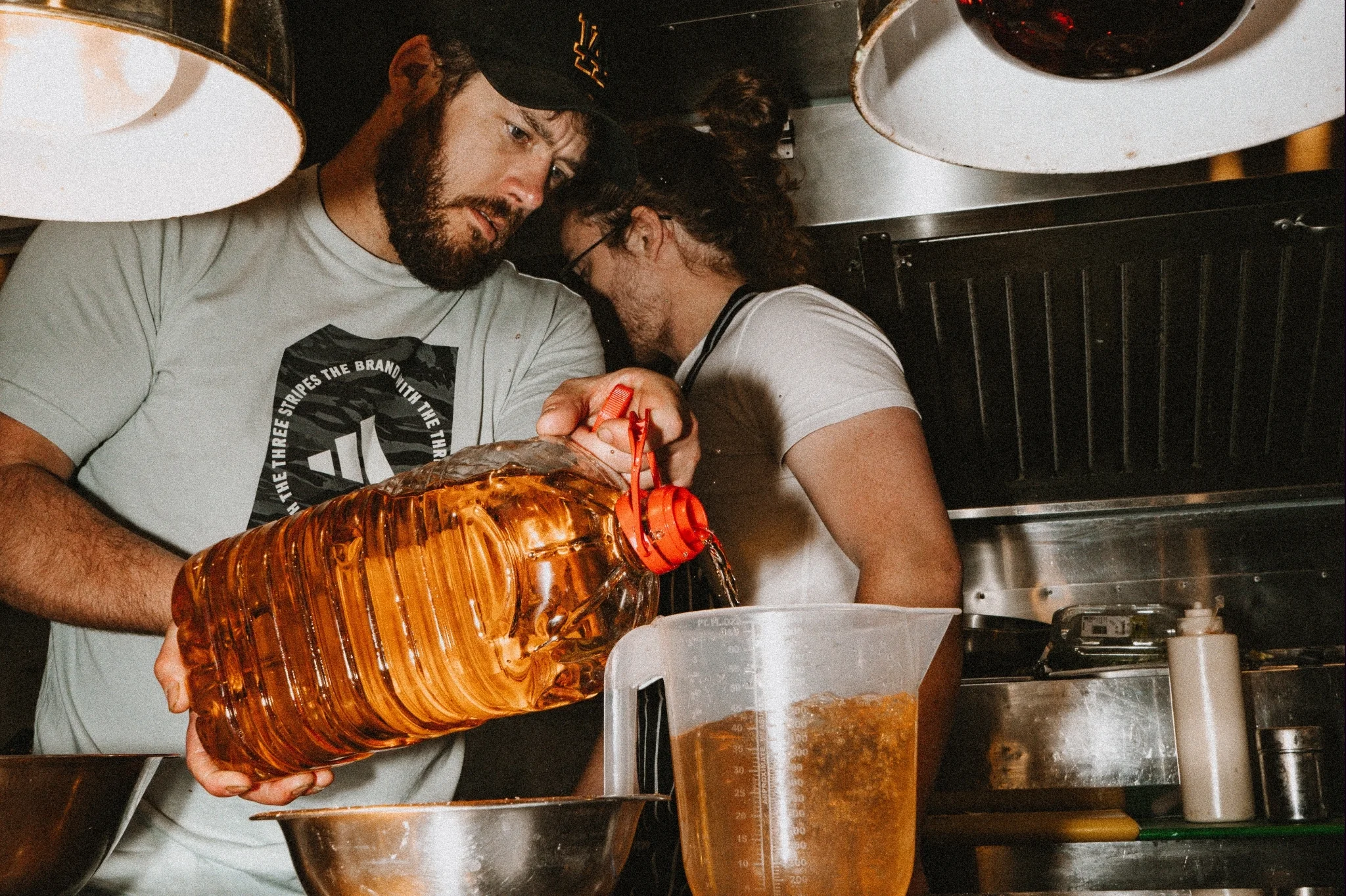 Restaurant employee pouring oil