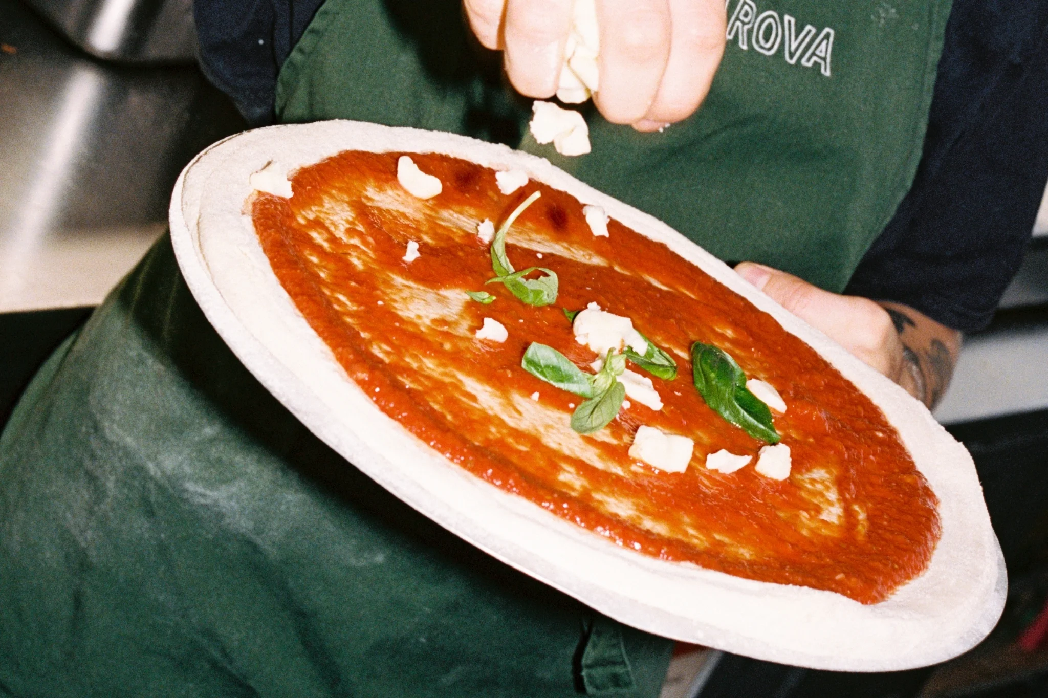 Pizza chef adding toppings to food