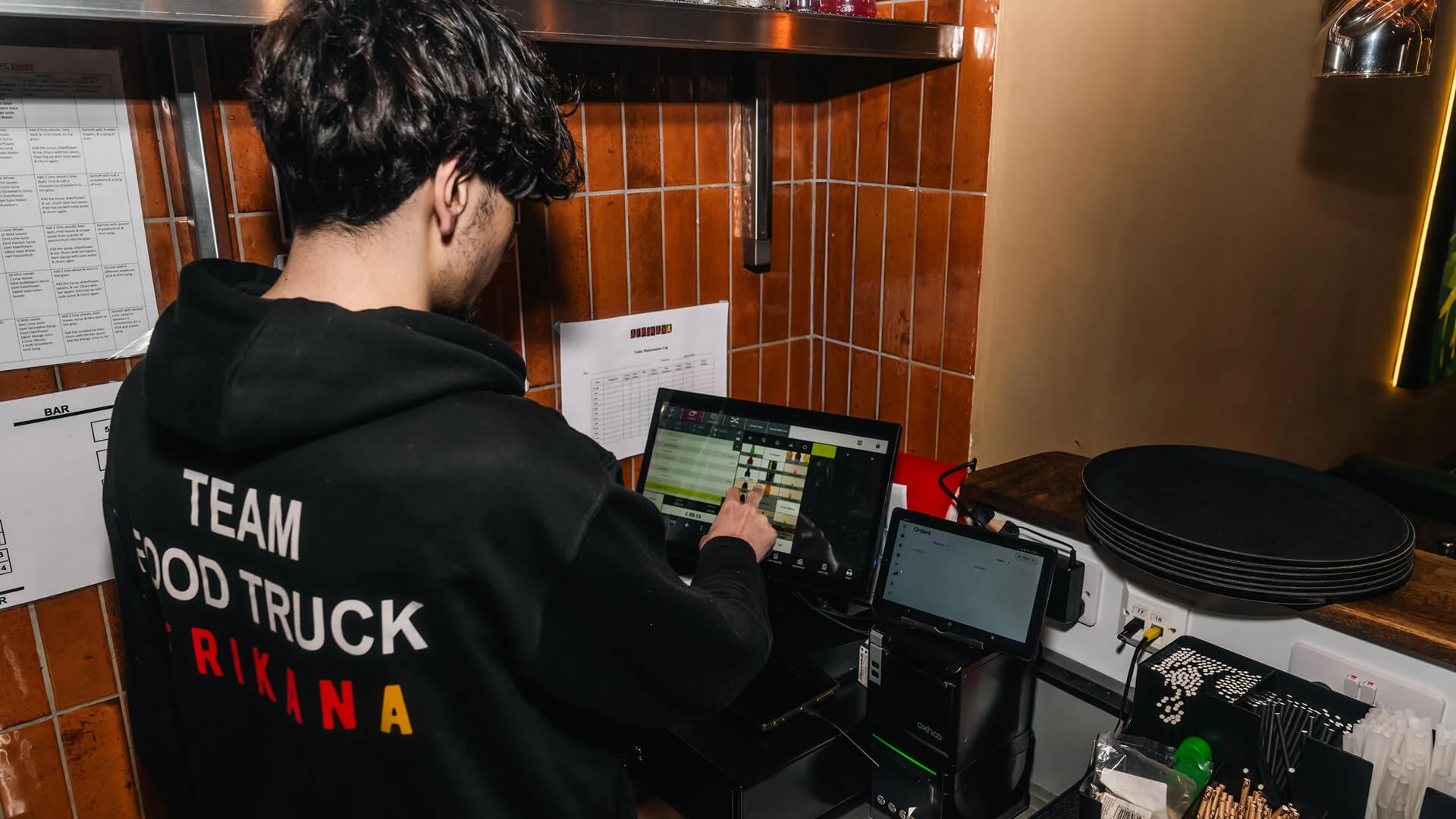 Restaurant employee using technology to handle customer orders
