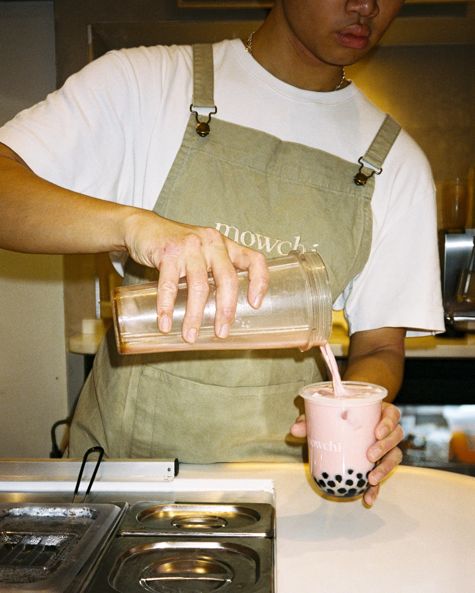 Cafe employee pouring a drink for a customer