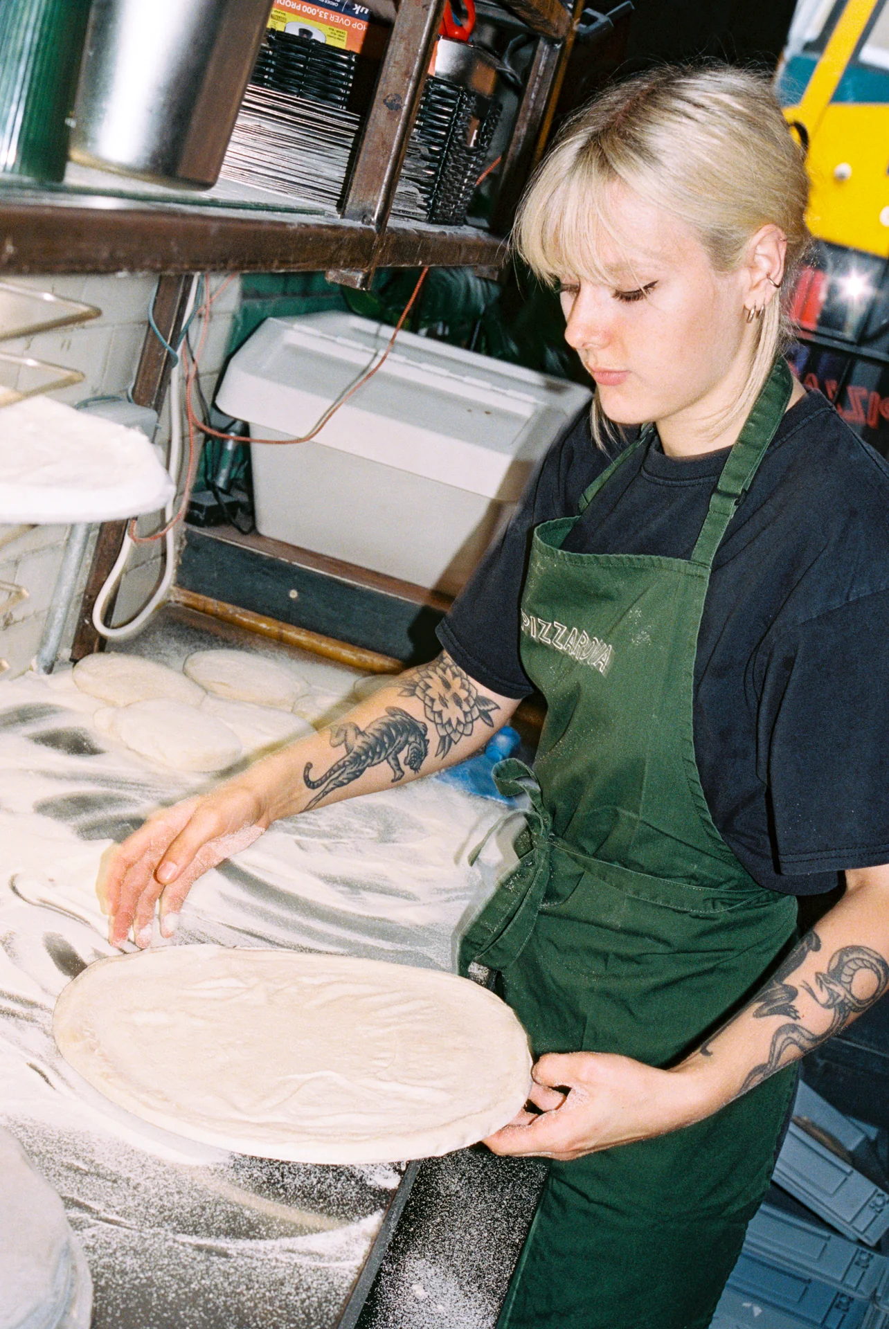 Restaurant employee preparing pizza dough for customers