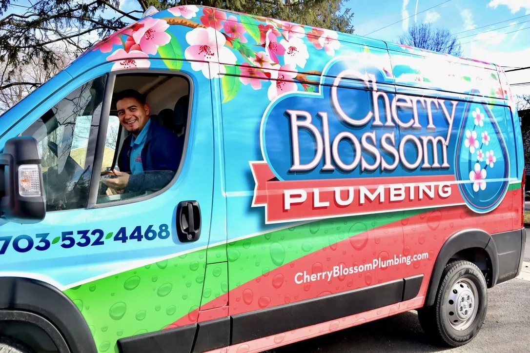 Colorful Cherry Blossom Plumbing van with floral design and smiling driver