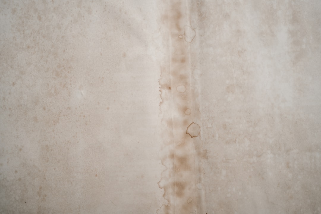 Beige stained surface with vertical water or rust mark