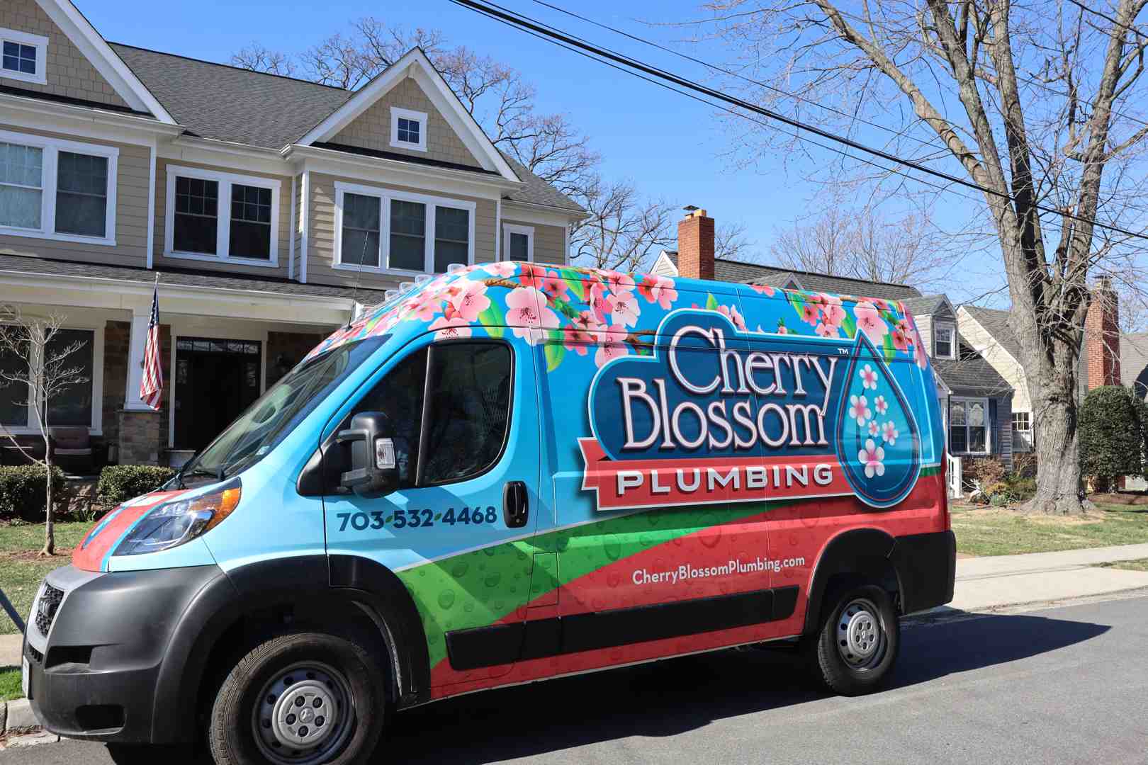 Colorful Cherry Blossom Plumbing van parked on residential street