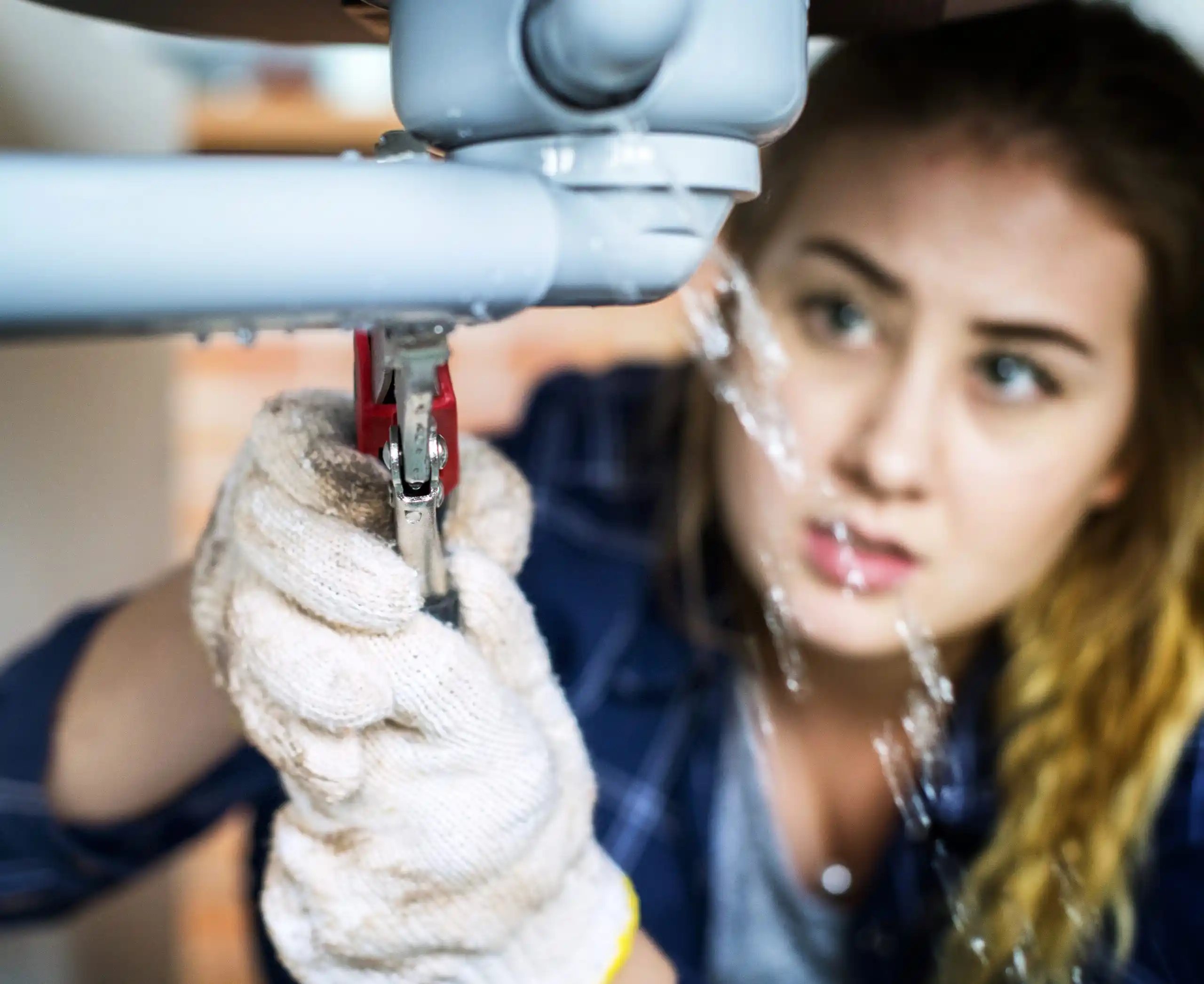 Technician in white gloves using industrial tool under blue machinery