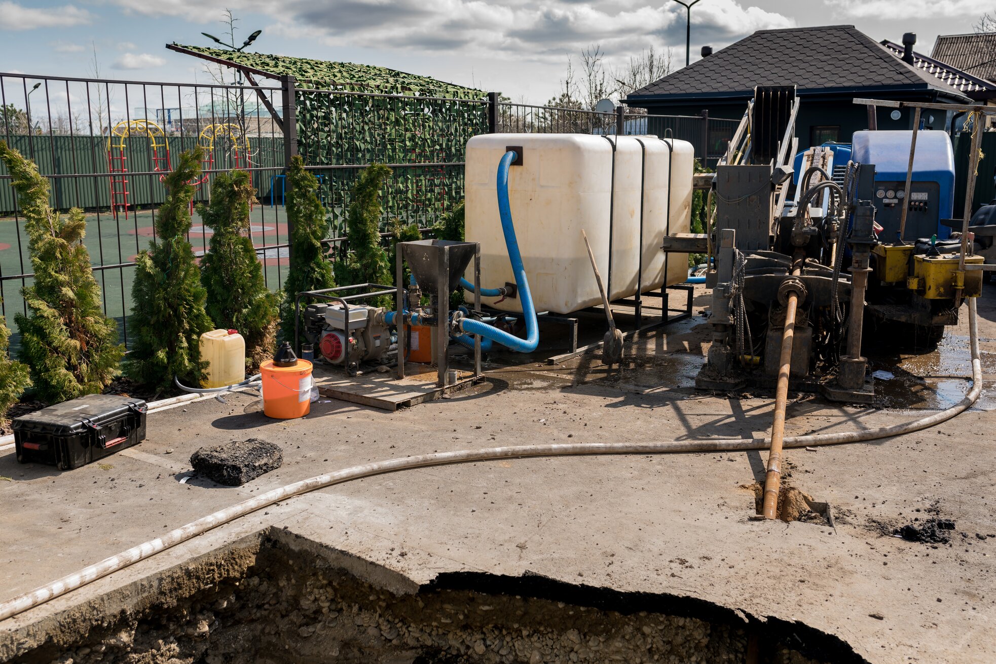Construction site with water tanks, machinery, and excavated ground