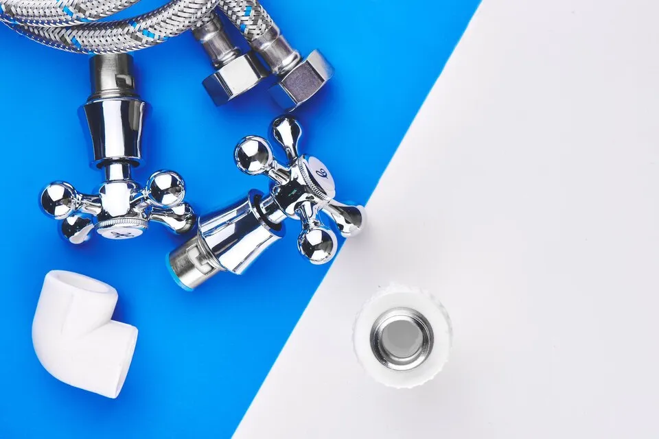 Plumbing fixtures and metal pipe connections on blue and white background