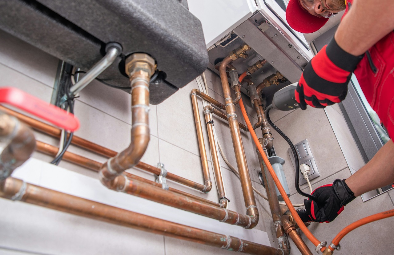 Technician working on copper pipes and heating system installation