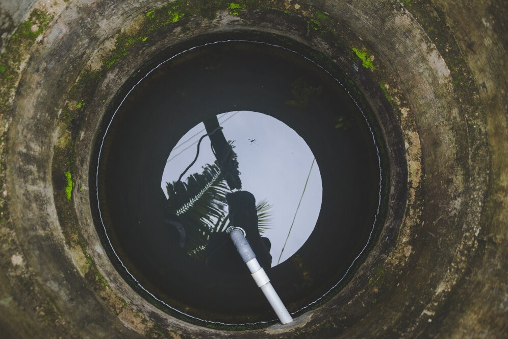 View of pole and moon through mossy concrete circular opening