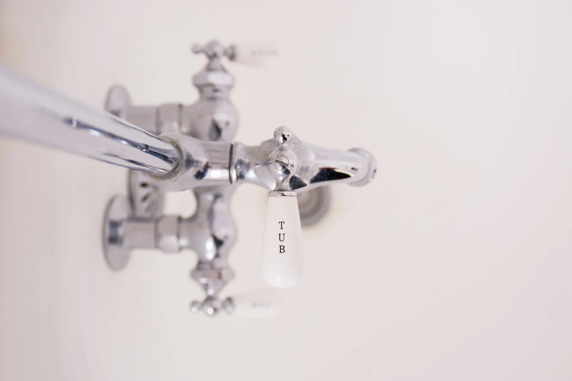 Vintage chrome water faucet with 'TUB' label against white background