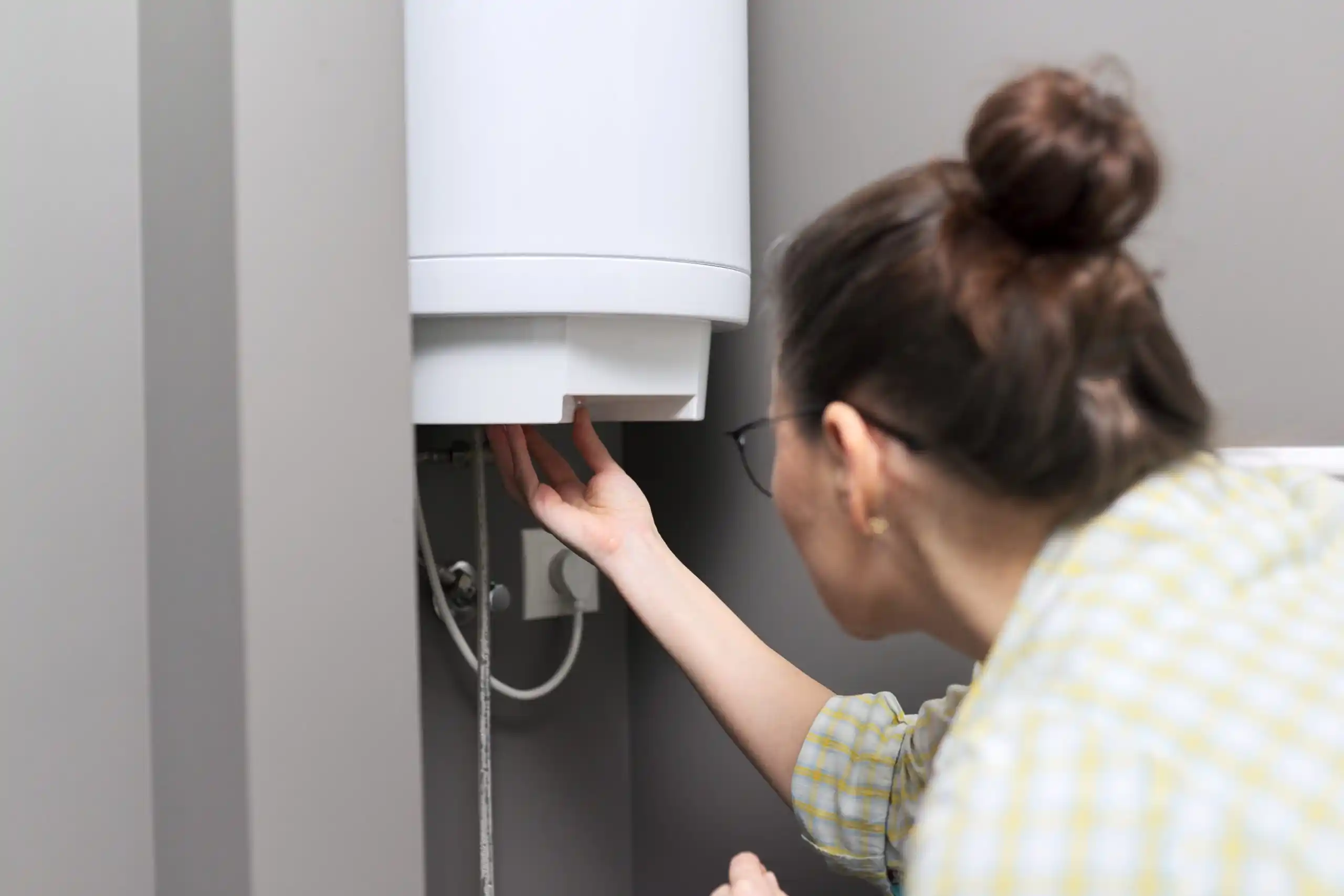Person checking water heater or electrical panel in home