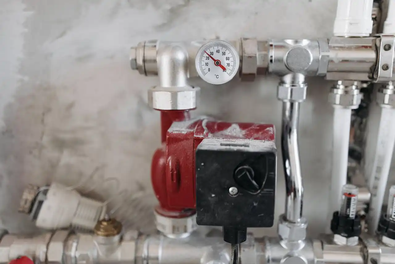 Industrial temperature gauge and pipes in heating system closeup
