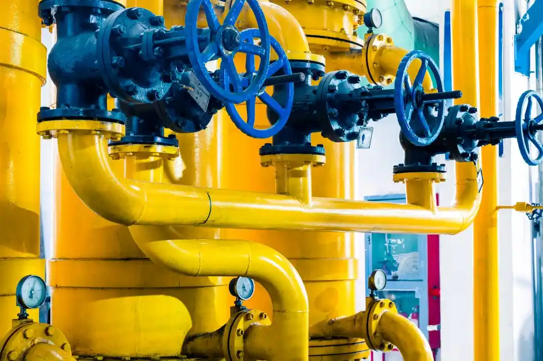 Yellow and blue industrial pipes with valves in a complex pipeline system