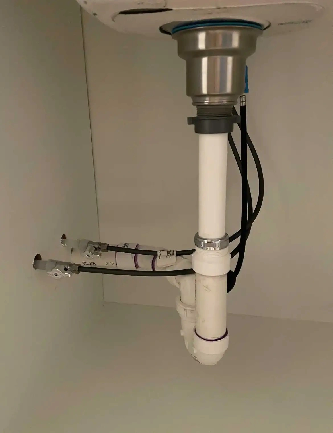 Sink drain pipe and plumbing connections under a kitchen or bathroom sink