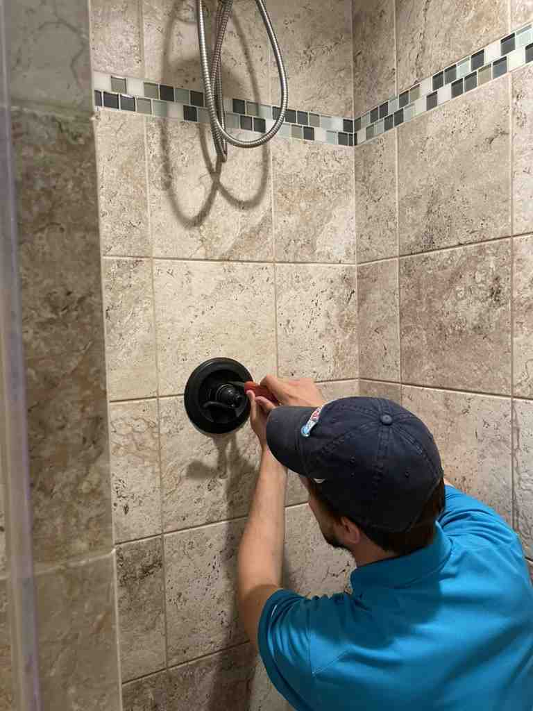 friendly, professional plumber working on a shower - shower faucet replacement fairfax
