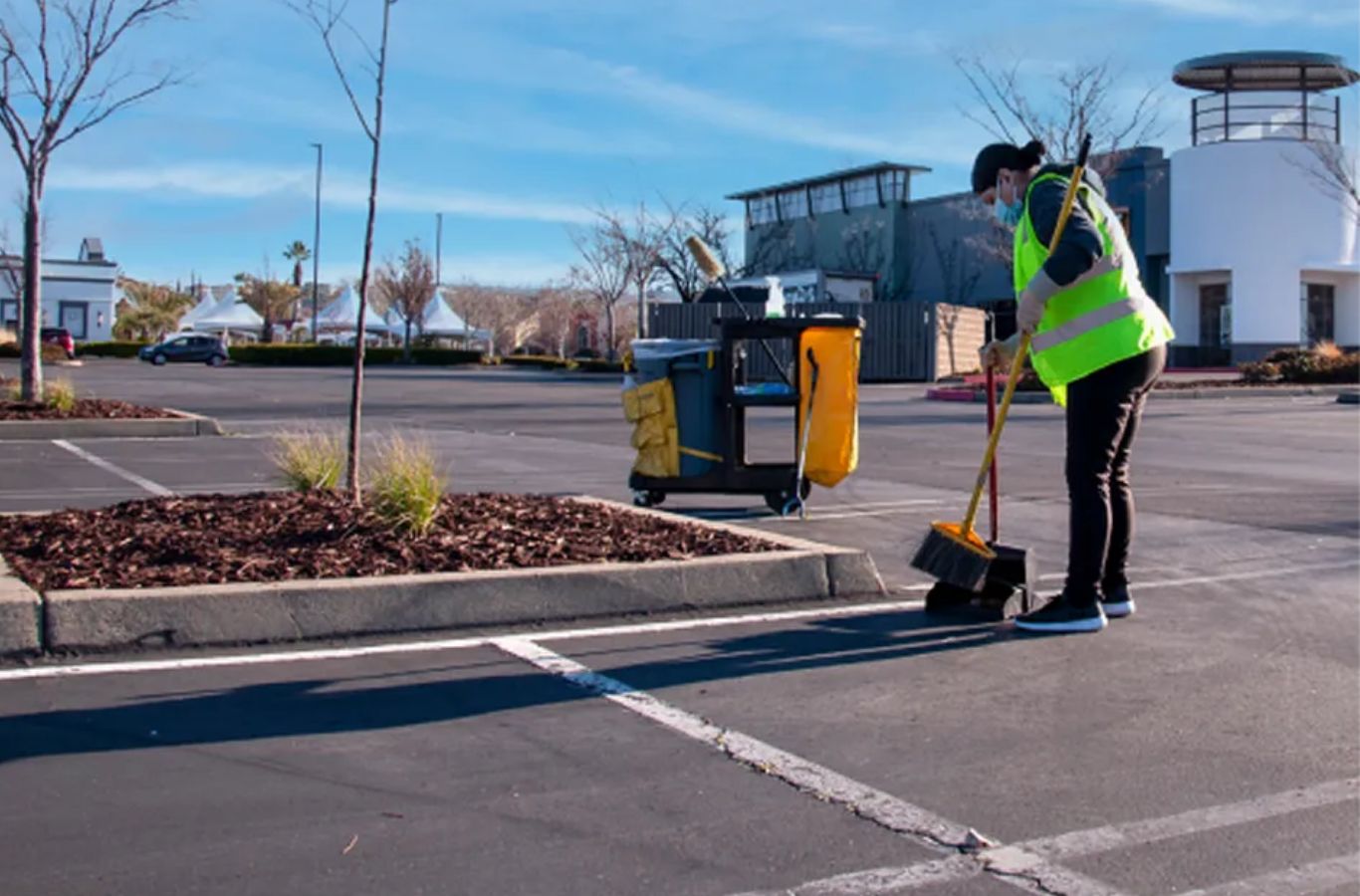 A Sundance Sweeping technician cleaning a parking lot in Gilbert, AZ, emphasizing property safety, cleanliness, and visual appeal.