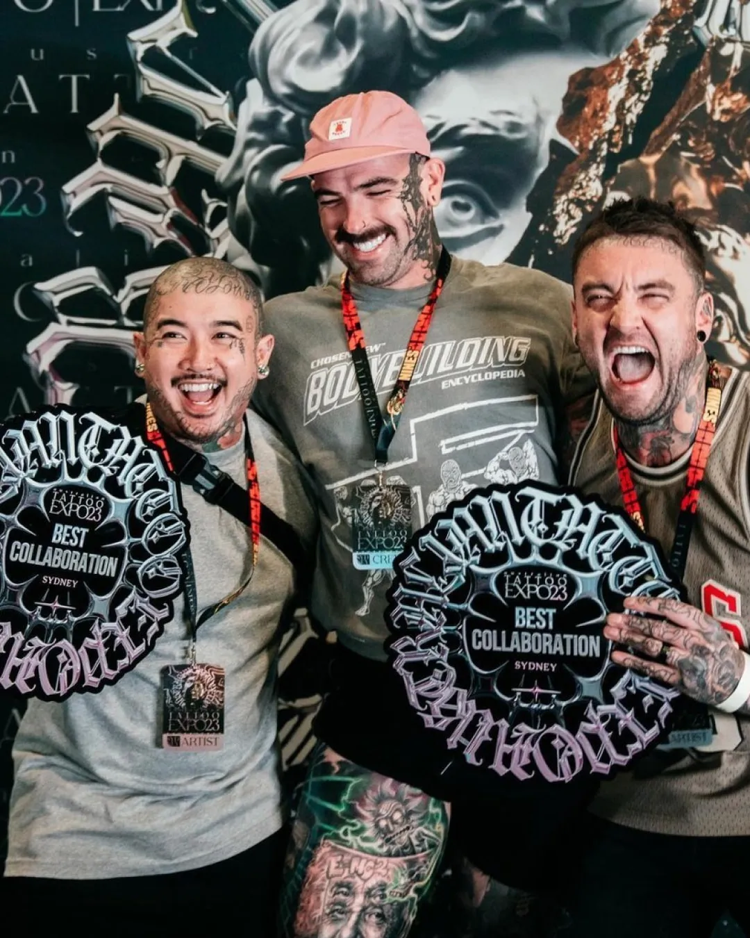 Tattoo artists celebrating and holding awards after winning competitions at the Australian Tattoo Expo