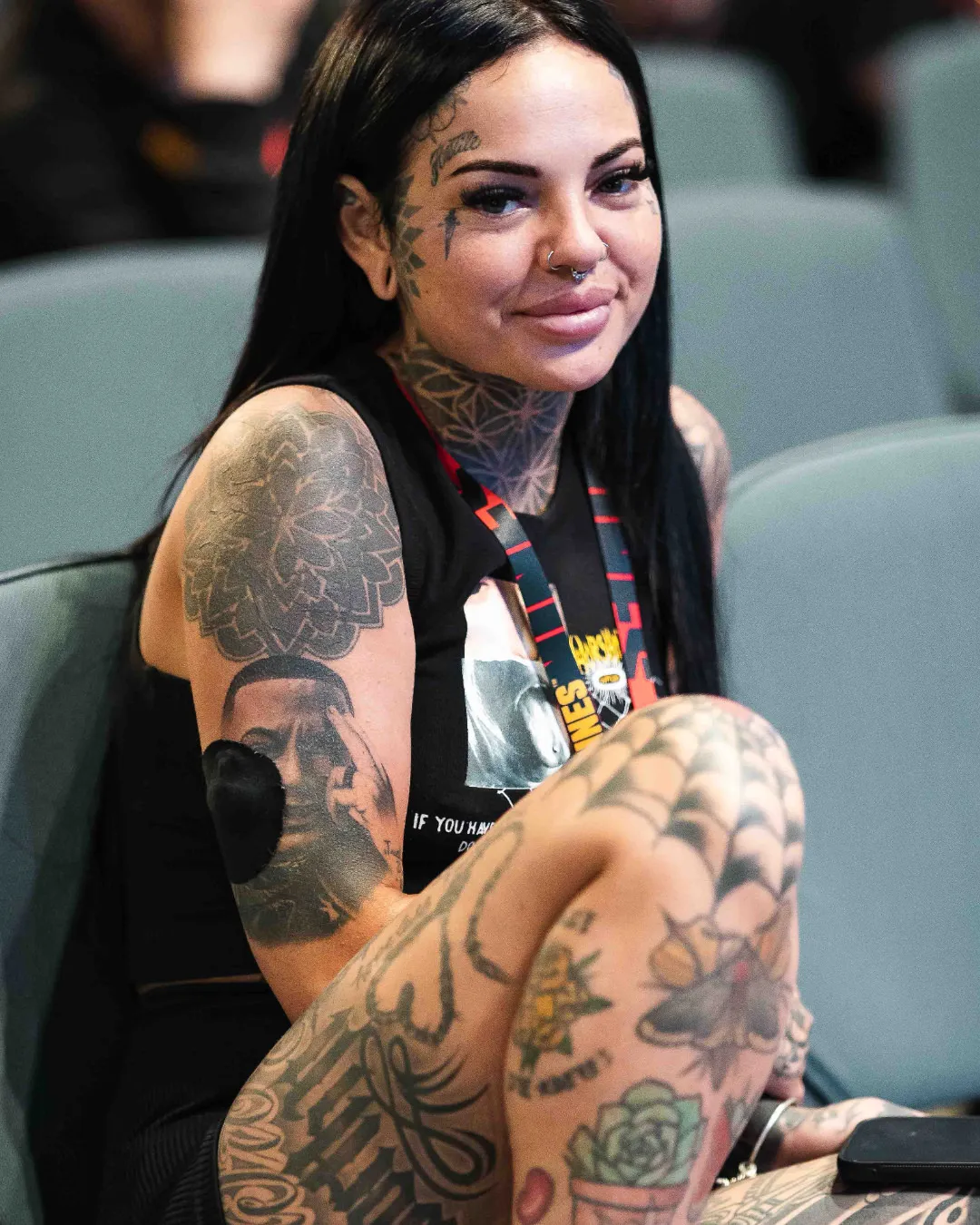 Tattoo enthusiast with long black hair showcasing fresh tattoos at the Australian Tattoo Expo