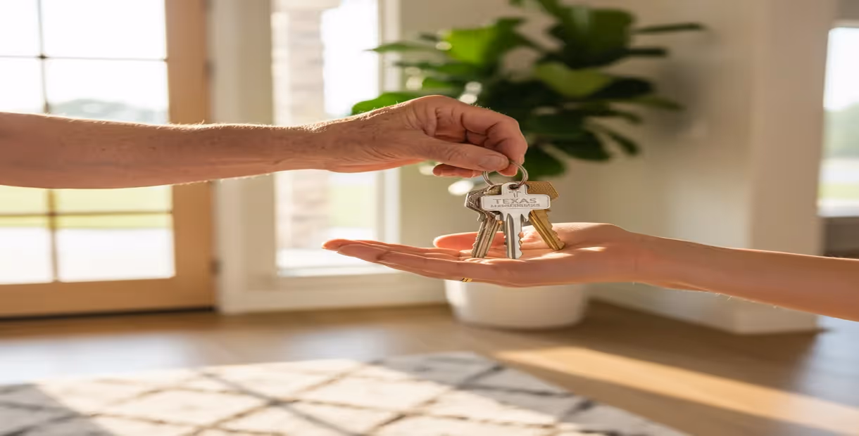 Parent's hand giving house keys to child.