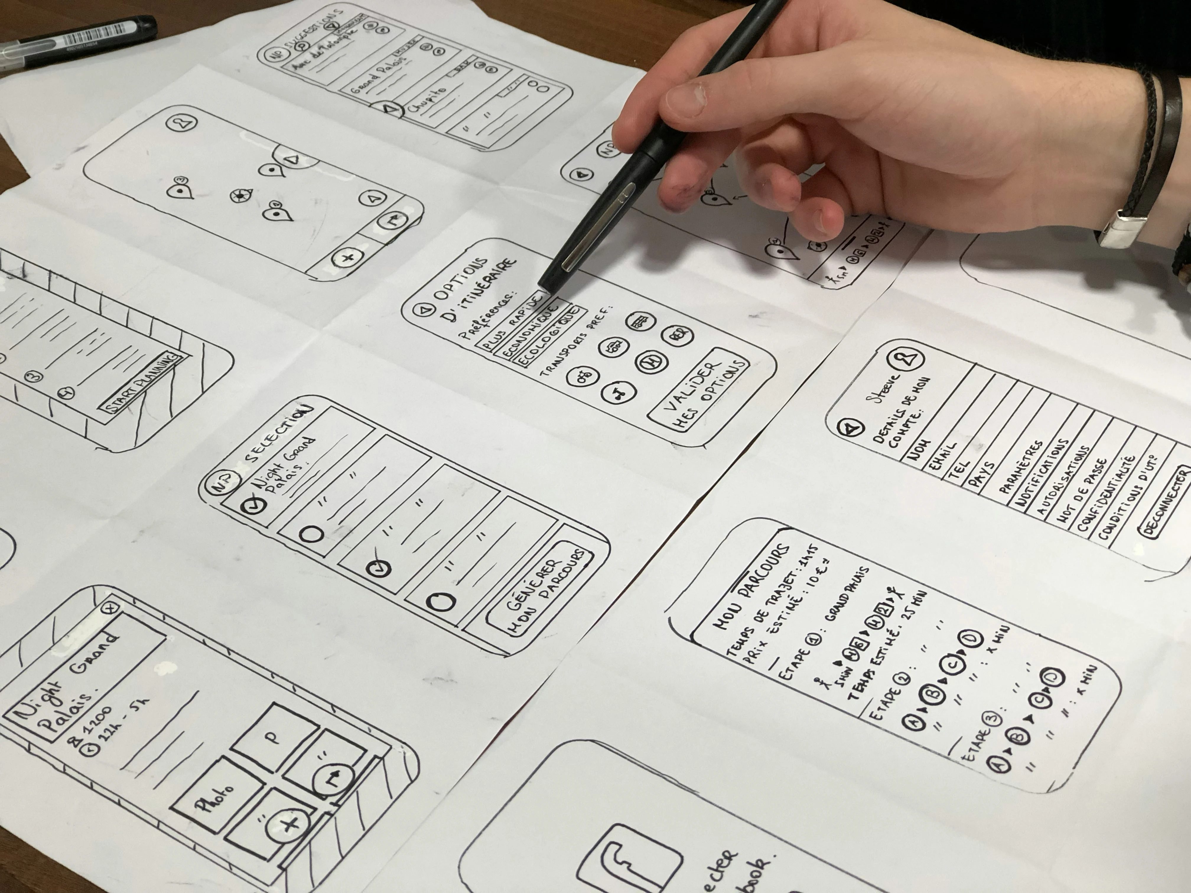 Responsive Design for Mobile Apps: Designer sketching wireframes with pen on paper, focusing on app interface layouts.