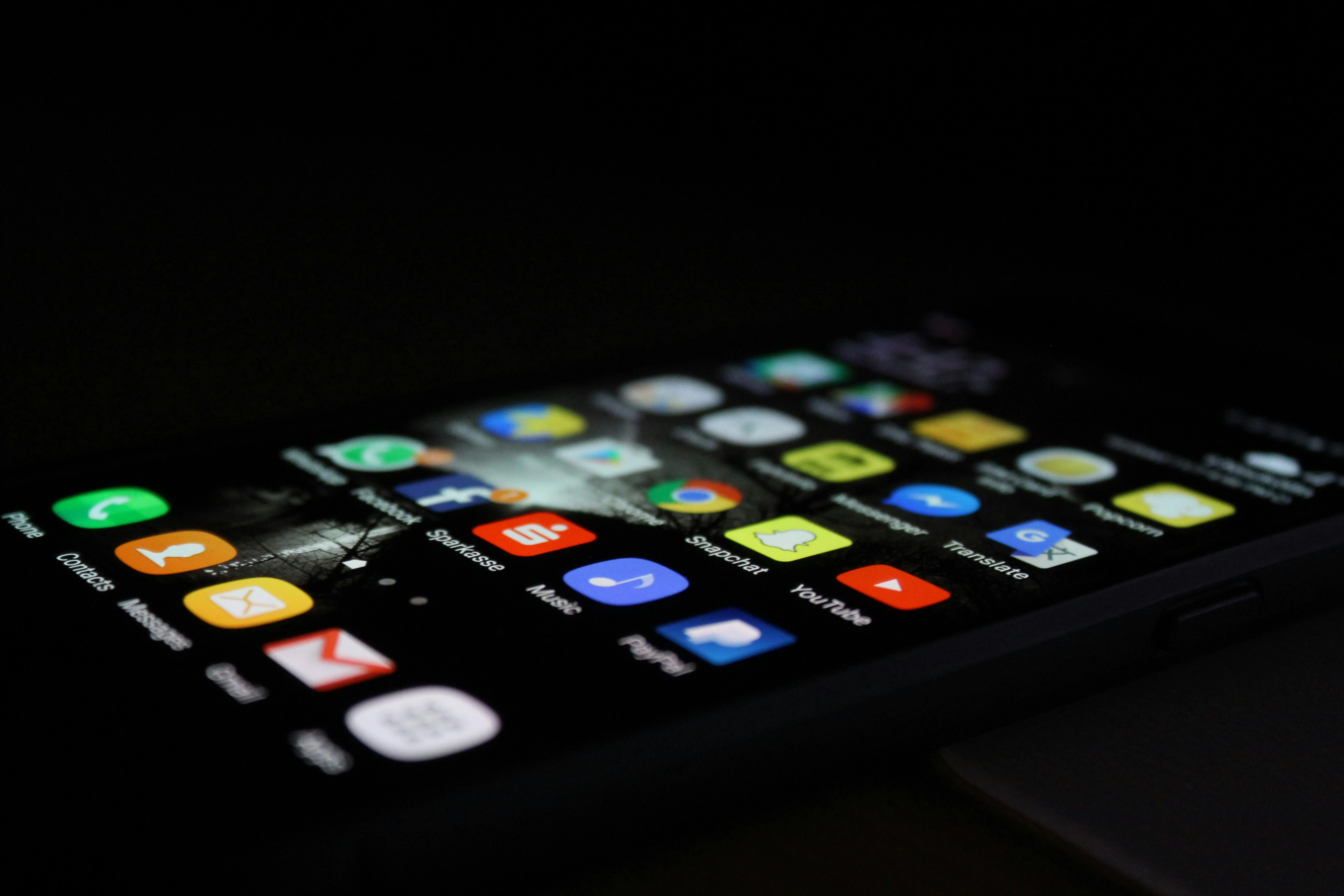 Smartphone screen displaying various app icons including Phone, Messages, Gmail, YouTube, and PayPal on a dark background, showcasing a mobile app interface.