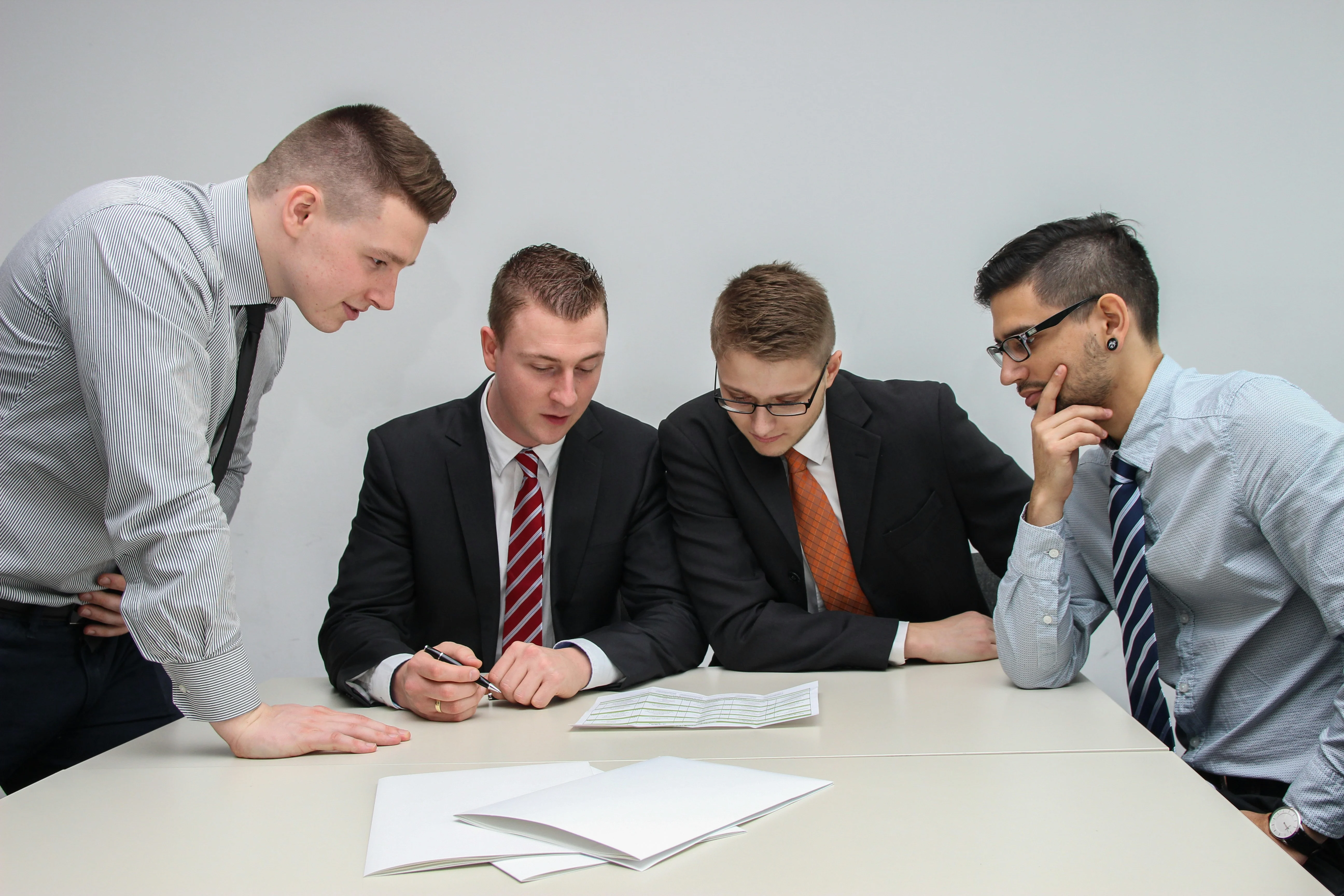 Team of professionals reviewing documents during a business meeting or user interview session.