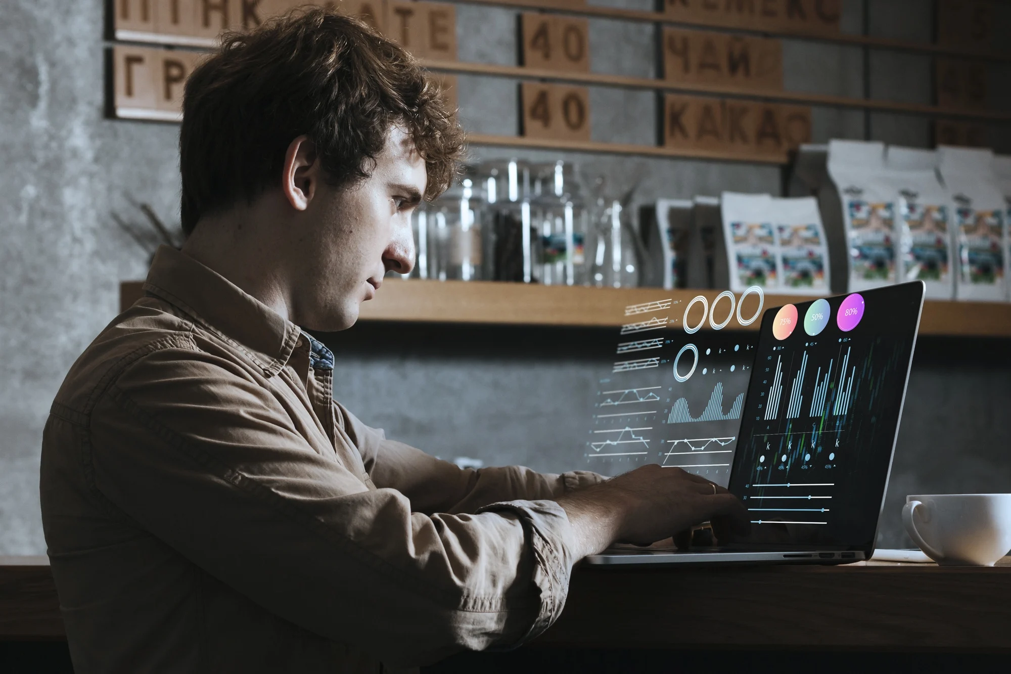 UX Researcher working on laptop with data analytics charts in a cozy cafe, showcasing modern technology and business analysis with coffee cup and shelves in background.