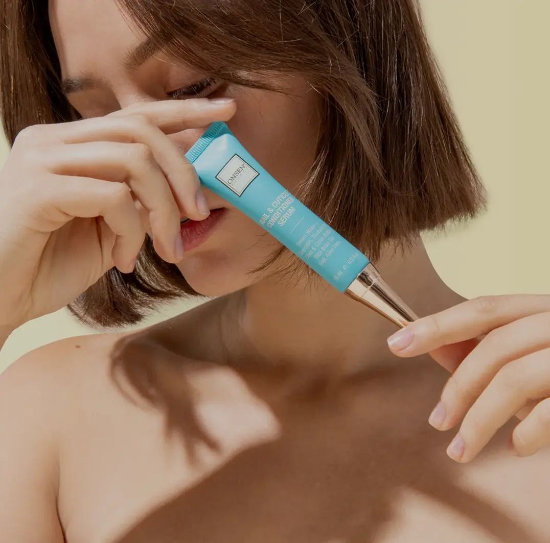 Woman applying Onsen Secret nose serum with blue applicator