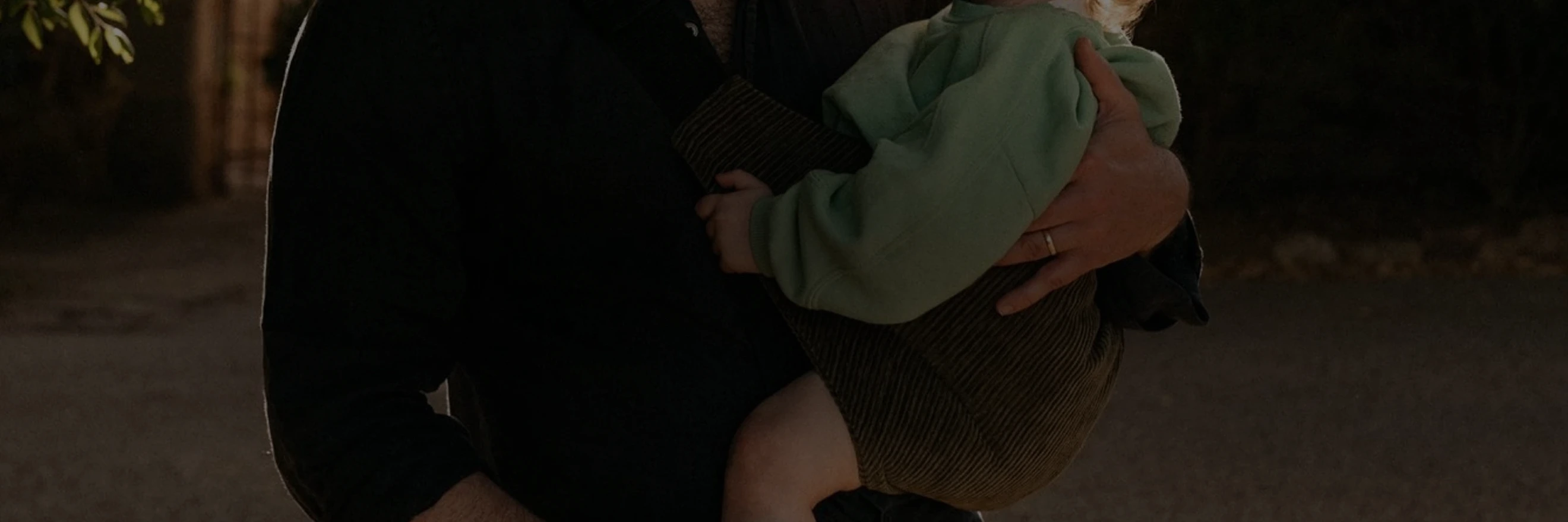 Parent carrying a sleepy child in a Wildride carrier