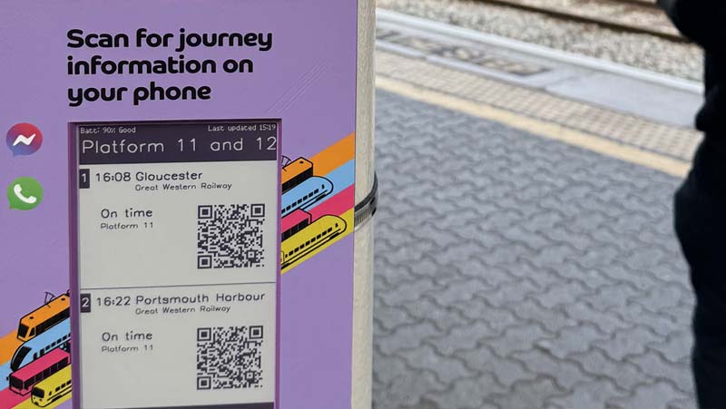 Foto eines Fahrgastes, der an einem violetten, solarbetriebenen QR-Code-Gerät am Bahnhof Bristol Templemeads vorbeigeht