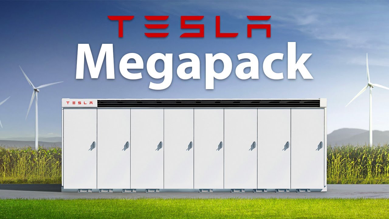 Tesla Megapack unit shown outdoors with wind turbines in the background, highlighting large-scale battery energy storage.