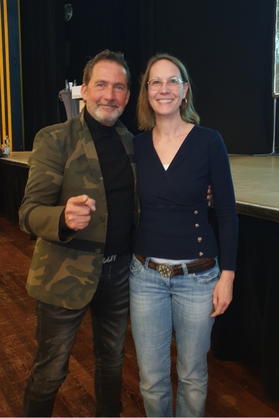 Ein Mann links und eine Frau rechts die lächeln