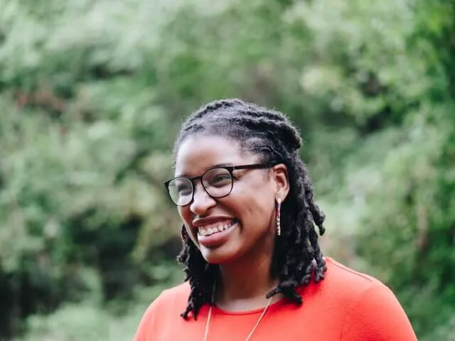 A woman wearing glasses and a red shirt.