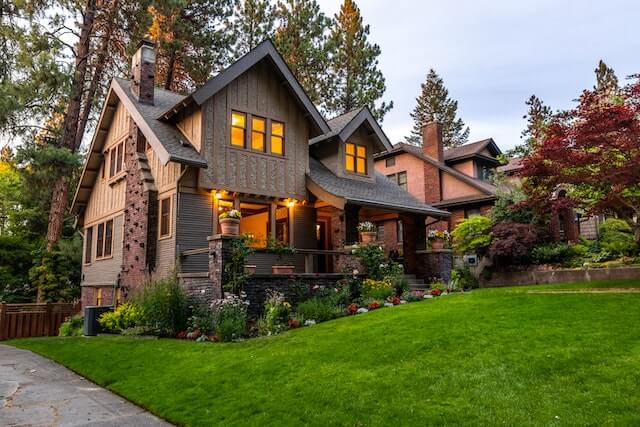 A house with a lot of trees and grass in front of it.