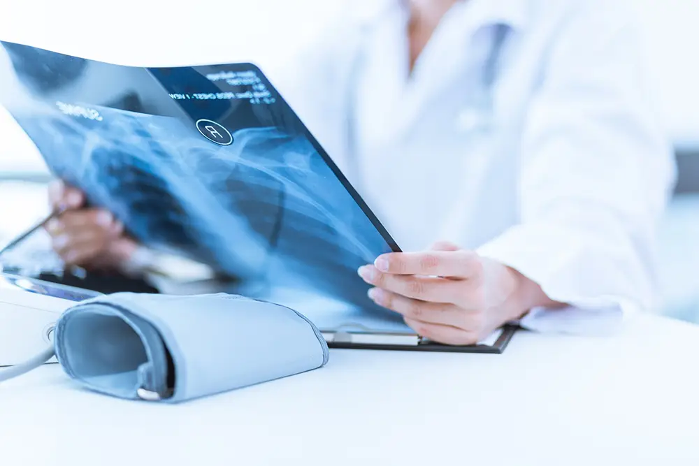 A doctor is looking at an x-ray of a spine.