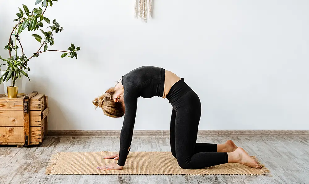 A younger woman does stretching exercises for her back.