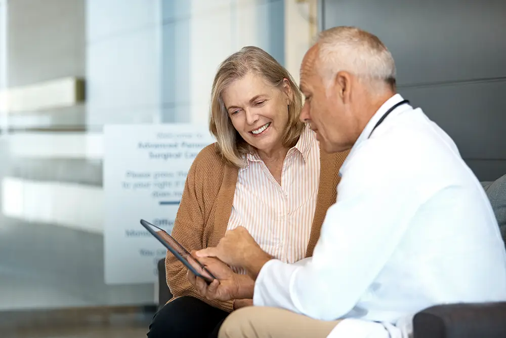 A doctor is speaking to happy older lady.