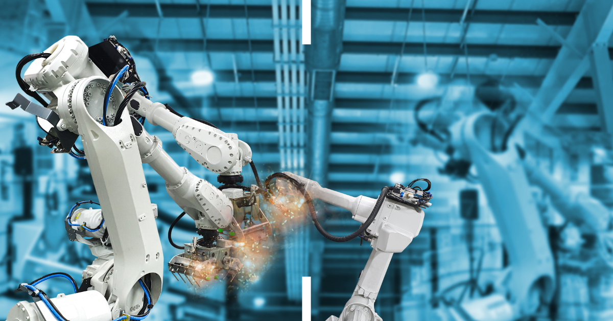 White robotic arms welding in a factory setting.