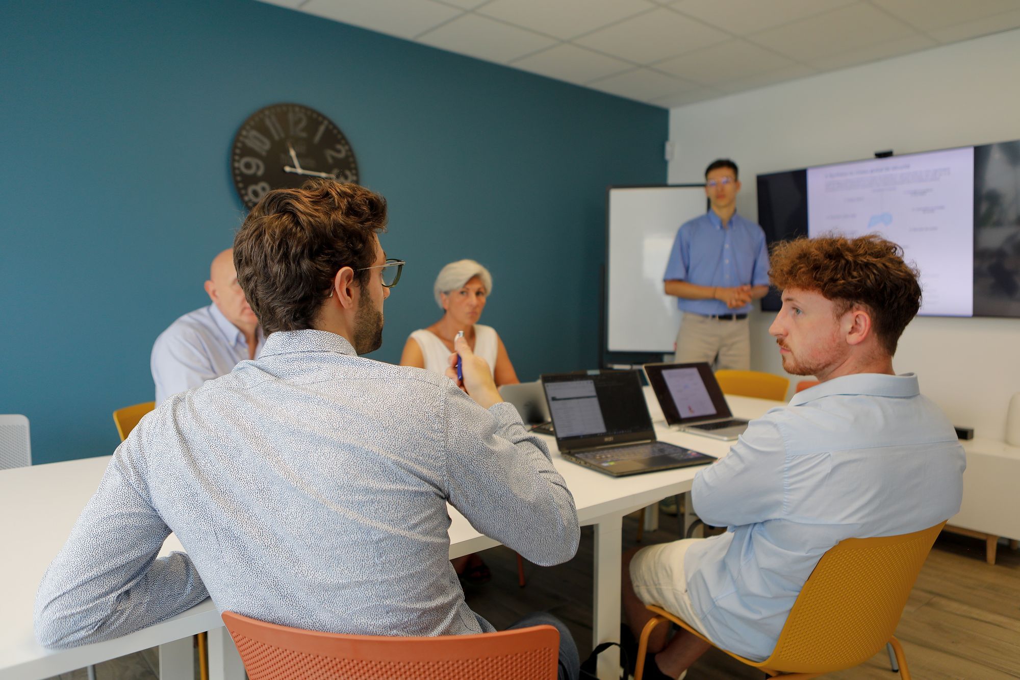 Réunion d’équipe chez CyberCAPE avec plusieurs collaborateurs autour d’une table, en pleine discussion sur un projet de cybersécurité.