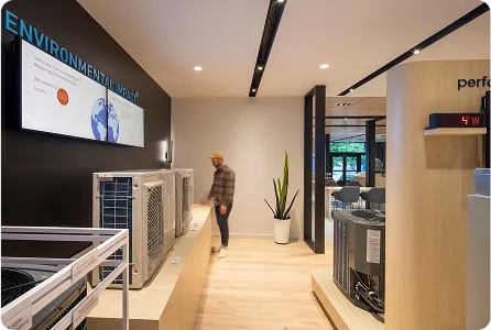 Modern office lobby with digital display and person standing near environmental signage